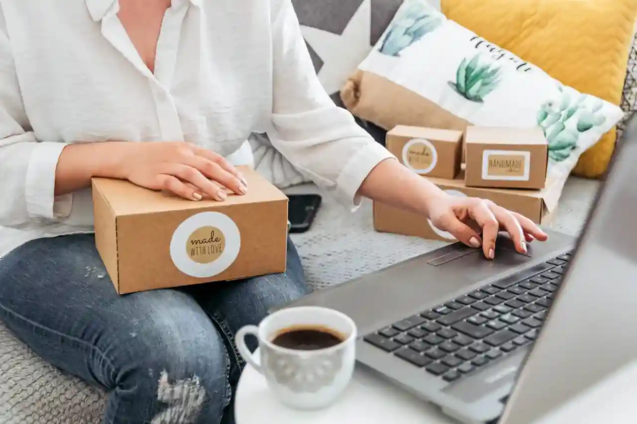 Versandpakete und ein Laptop mit geöffnetem Onlineshop