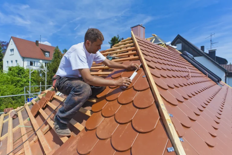 Dachdecker deckt ein Steildach mit roten Ziegeln neu ein